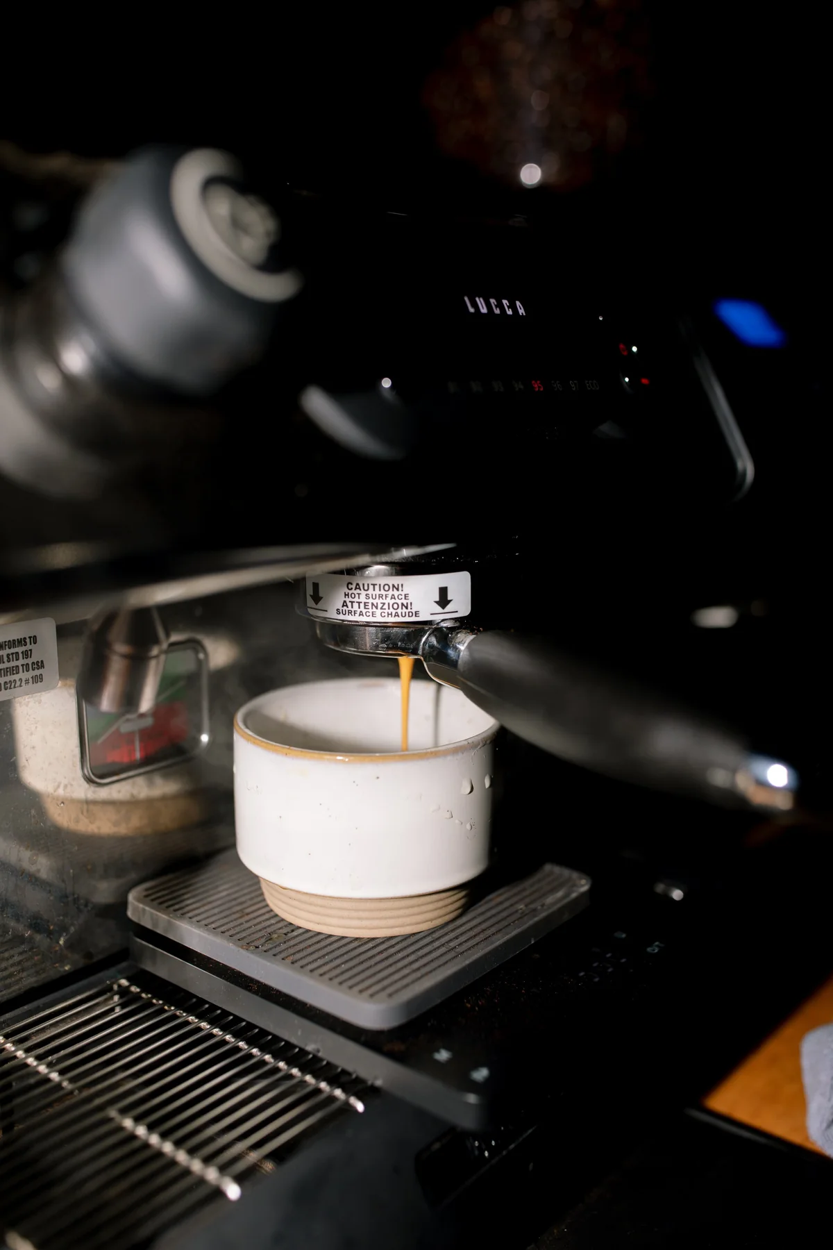 Barista pulling an espresso shot on commercial equipment at an event coffee bar
