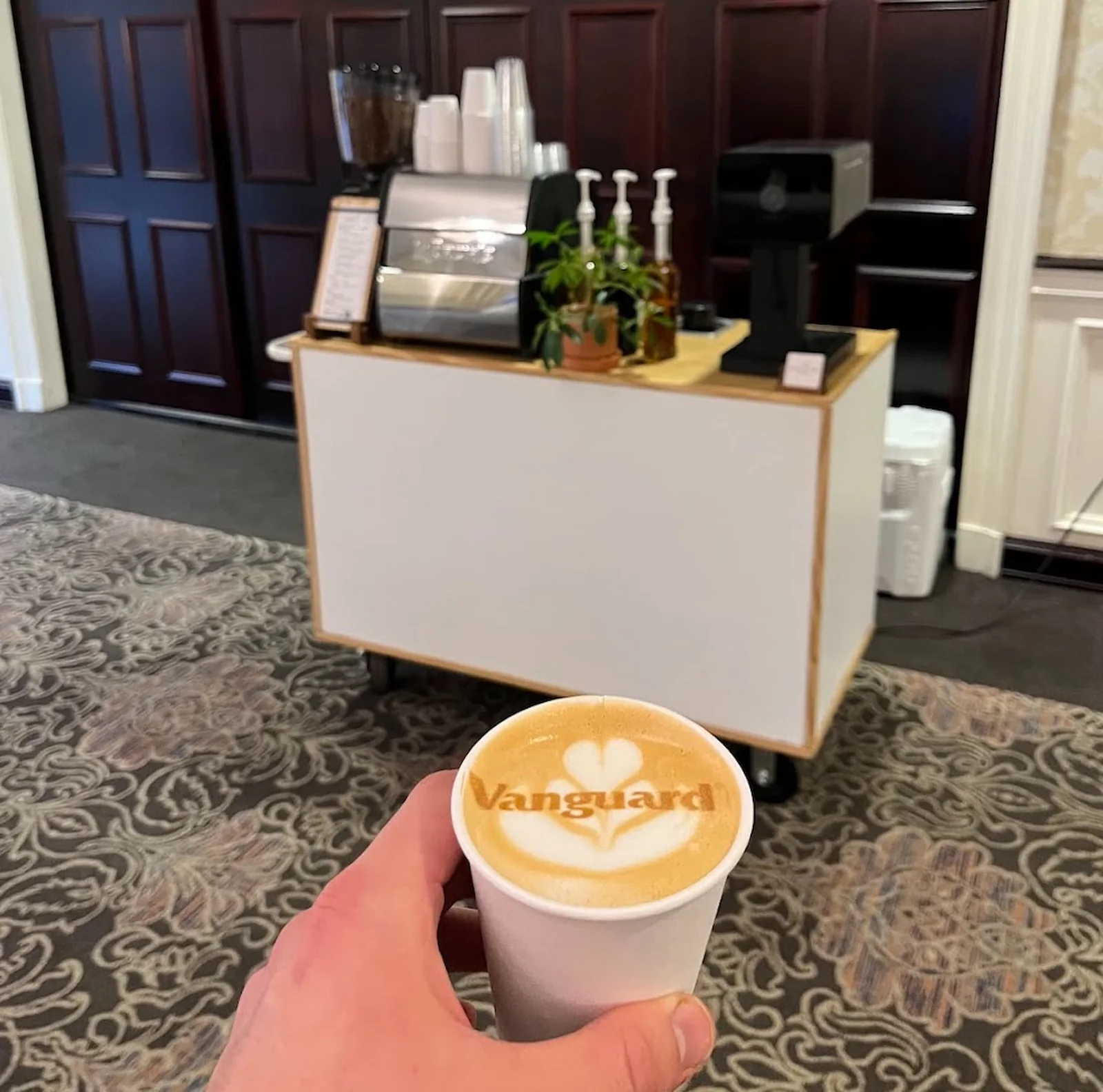 Latte with the Vanguard logo printed in the foam, served at a corporate coffee catering event