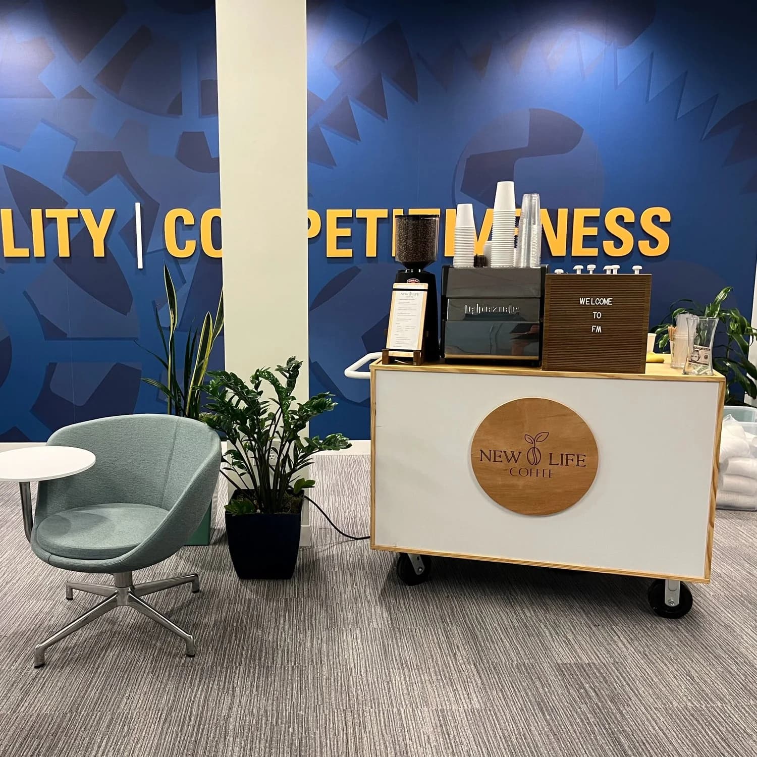 Coffee cart set up in a corporate conference lounge with branded blue backdrop