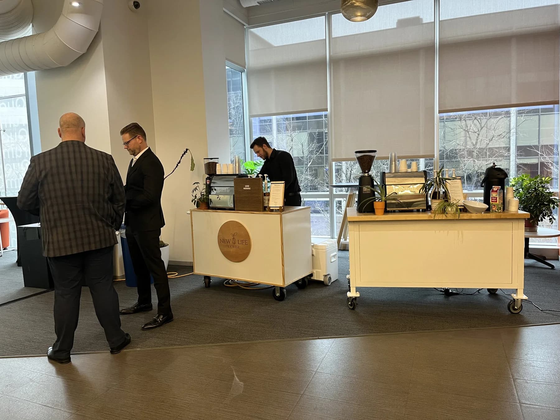 Attendees gathered at a New Life Coffee Company cart in an event lobby