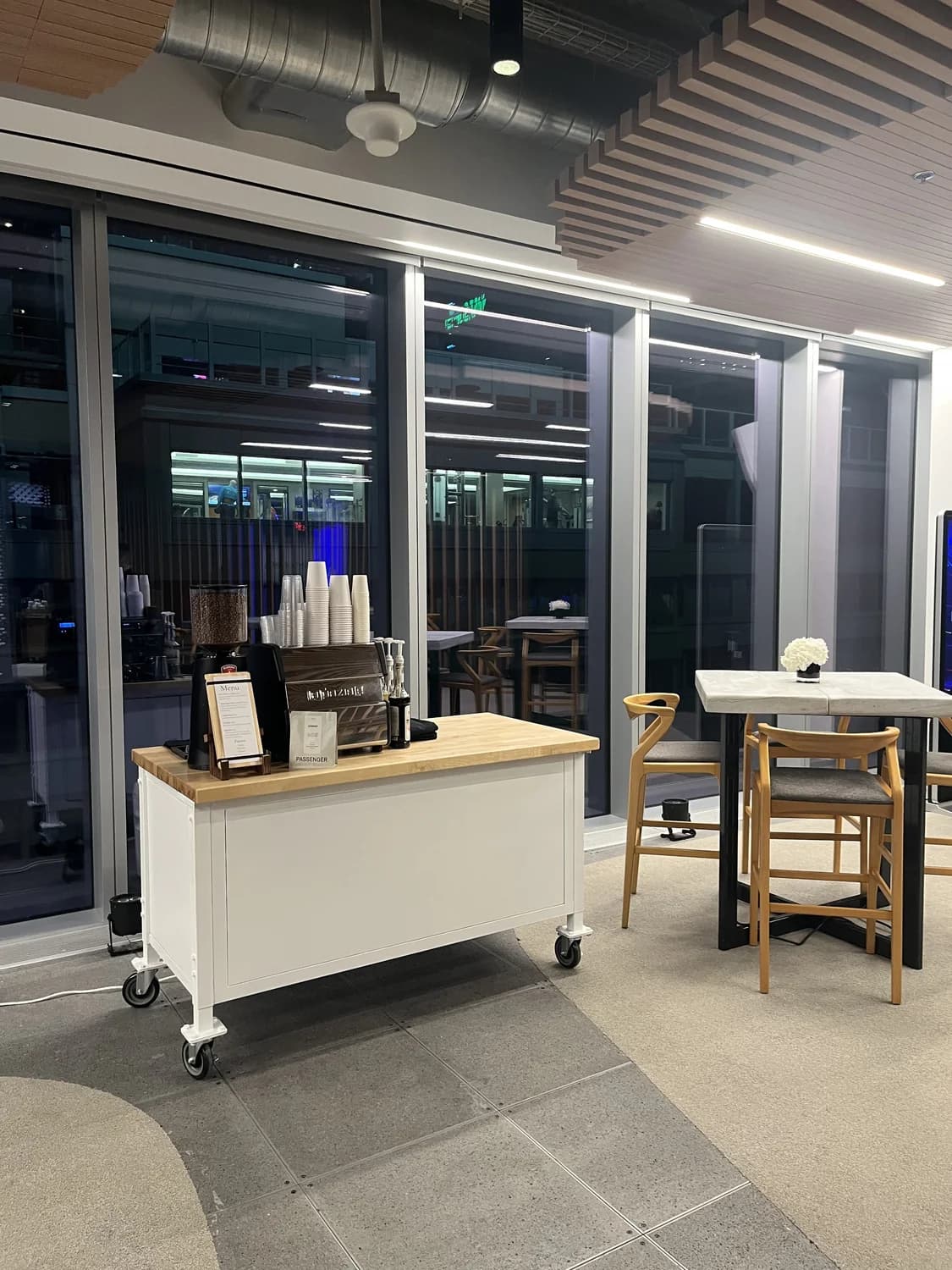 Mobile espresso bar set up along a glass corridor at a conference venue