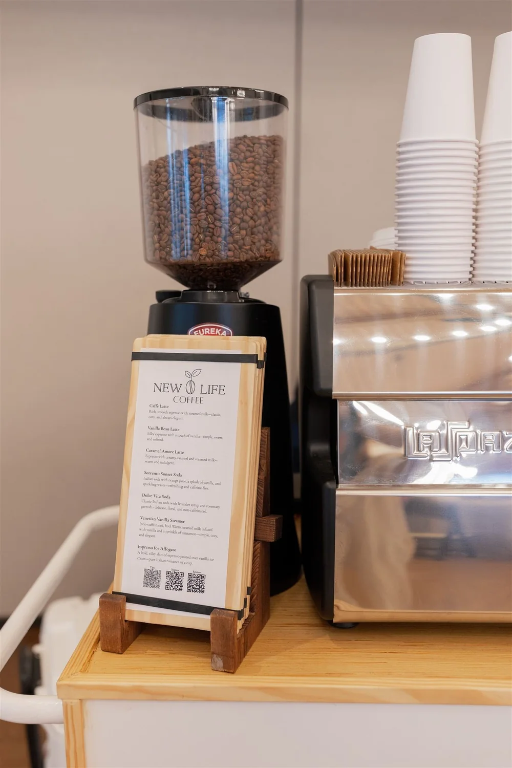 Commercial espresso grinder and stacked cups on the cart